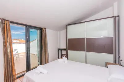 a bedroom with two beds and a large window at HomeHolidaysRentals Escapade in Pineda de Mar