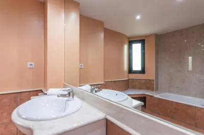 a bathroom with a sink and a toilet and a mirror at HomeHolidaysRentals Escapade in Pineda de Mar