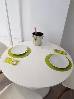 a white table with green plates and glasses on it at Krm Suite Apartament in Calella