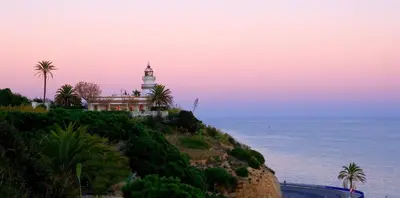 a lighthouse on a hill next to the ocean at Krm Suite Apartament in Calella