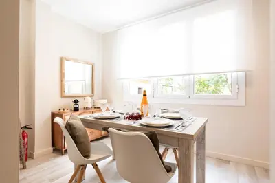 a dining room with a wooden table and chairs at Chic Apartments Barcelona in Barcelona