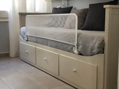 a bed with drawers in a room with a couch at Discover Sitges Center&Beach, a un minuto del mar in Sitges