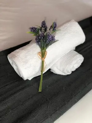 a bouquet of purple flowers in a white towel at Discover Sitges Center&Beach, a un minuto del mar in Sitges