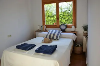 two beds in a room with two blue towels on them at Villa Sitges Colibri at 10 min Walk Beaches - Center City Amaizing Garden Pool XXL Private Tenis Piste in Vilanova i la Geltrú