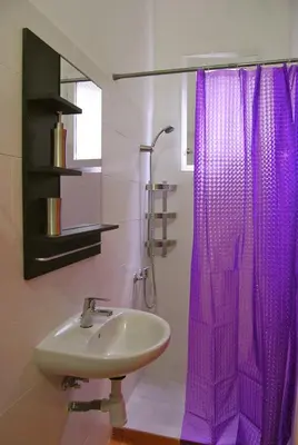 a bathroom with a sink and a purple shower curtain at Clot MiraBarna Apartments in Barcelona