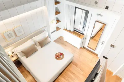 a small bedroom with a white bed and two windows at Casa Bella Gracia by Aspasios in Barcelona