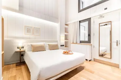 a white bedroom with a large bed and a window at Casa Bella Gracia by Aspasios in Barcelona
