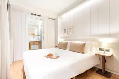 a white bedroom with a bed with a tray of food on it at Casa Bella Gracia by Aspasios in Barcelona