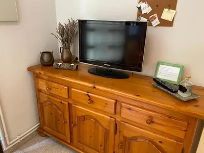a television sitting on top of a wooden dresser at El Porxo de Can Baixeres PB-00318 in Montseny