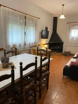 a living room with a table and a fireplace at El Porxo de Can Baixeres PB-00318 in Montseny