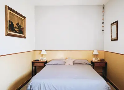 a bedroom with a bed with two nightstands and two lamps at El Porxo de Can Baixeres PB-00318 in Montseny