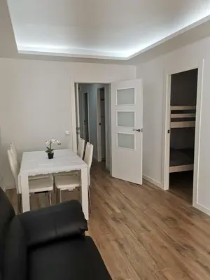a living room with a white table and chairs at Apartamento a 100 metros de la playa in Pineda de Mar