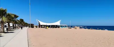 a large white tent on a beach next to the ocean at Apartamento a 100 metros de la playa in Pineda de Mar