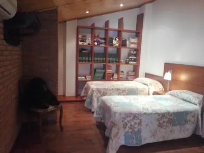 a room with three beds and a book shelf at agradable y familiar in Premiá de Mar