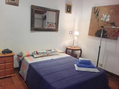 a bedroom with a bed with a mirror on the wall at agradable y familiar in Premiá de Mar