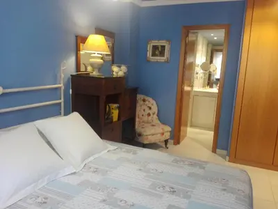 a bedroom with a bed and a lamp and a chair at agradable y familiar in Premiá de Mar