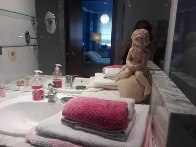 a baby sitting on a pile of towels in a bathroom at agradable y familiar in Premiá de Mar