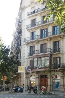 a person riding a bike in front of a building at Som Nit Triomf in Barcelona