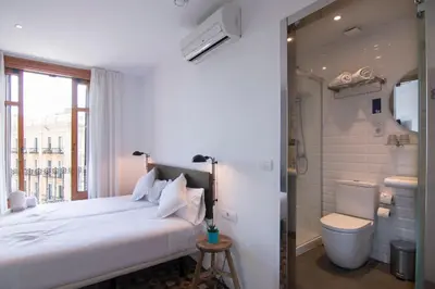 a bedroom with a bed and a shower and a toilet at Som Nit Triomf in Barcelona