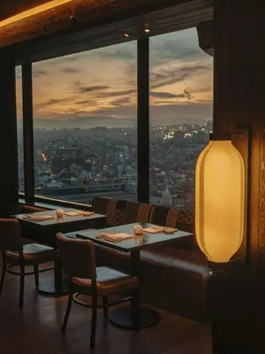 a restaurant with two tables and a view of a city at Nobu Hotel Barcelona in Barcelona