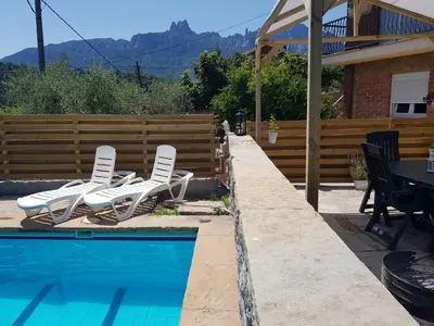 a pool with white chairs and a table and a fence at Apartament Vall de Montserrat in Castellbell i Vilar