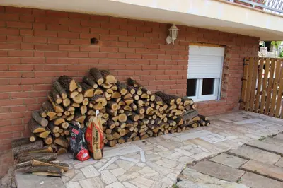 a pile of fire wood next to a brick wall at Apartament Vall de Montserrat in Castellbell i Vilar