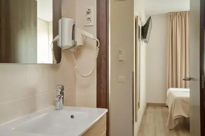 a bathroom with a sink and a phone on the wall at Hostal Centric in Barcelona