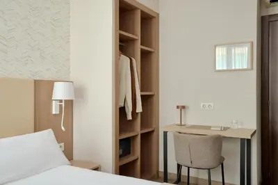 a bedroom with a bed and a desk and a chair at Hostal Centric in Barcelona