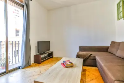 a living room with a couch and a tv at Basic Platja in Barcelona