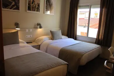 a small bedroom with a bed and a desk at Hostal La Romànica in Sabadell