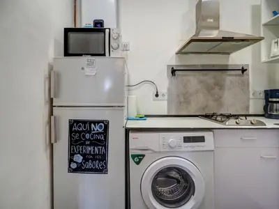 a kitchen with a refrigerator and a washing machine at Gladiator Apartment by Hello Homes Sitges in Sitges