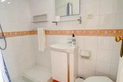 a white bathroom with a sink and a toilet at Gladiator Apartment by Hello Homes Sitges in Sitges