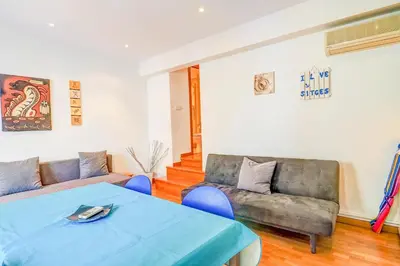 a living room with a couch and a table at Aire Apartment by Hello Homes Sitges in Sitges