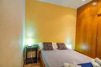 a small bedroom with a bed and a desk at Aire Apartment by Hello Homes Sitges in Sitges
