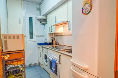 a kitchen with a washing machine and a sink at Aire Apartment by Hello Homes Sitges in Sitges