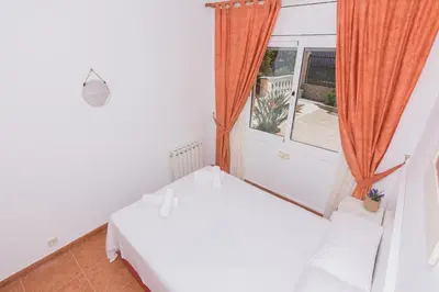 a white room with a bed and a window at HomeHolidaysRentals Aube in Sant Cebrià de Vallalta