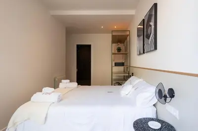 a bedroom with a large bed with white sheets and pillows at Petit Luxe Tobella Baixos in Terrassa