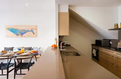 a kitchen with a counter and a table with chairs at Petit Luxe Tobella Baixos in Terrassa