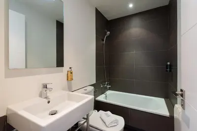 a bathroom with a sink and a toilet and a bath tub at Petit Luxe Tobella Baixos in Terrassa