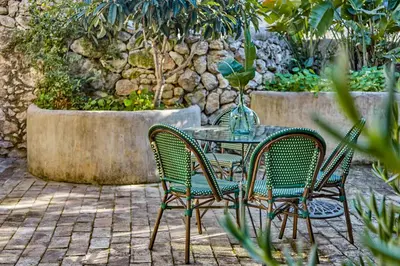 a table and chairs with a vase on it at Casa Marqués at Masia Nur Sitges, Adults only in Canyelles