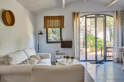 a living room with a white couch and a tv at Casa Granada at Masia Nur Sitges, with private pool and adults only in Canyelles