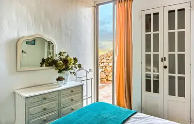 a bedroom with a dresser and a mirror and a window at Casa Granada at Masia Nur Sitges, with private pool and adults only in Canyelles