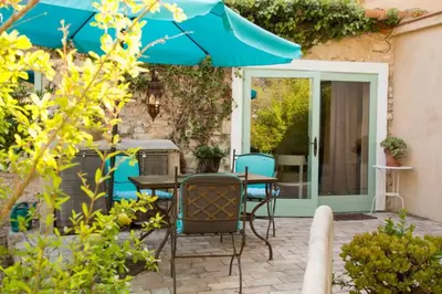 a patio with a table and chairs and an umbrella at Casa La Premsa at Masia Nur Sitges, Adults only in Canyelles