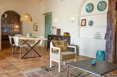 a living room with a table and chairs at Casa La Premsa at Masia Nur Sitges, Adults only in Canyelles