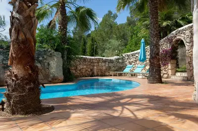 a swimming pool in a yard with palm trees at Casa Jasmin at Masia Nur Sitges, Adults only in Canyelles