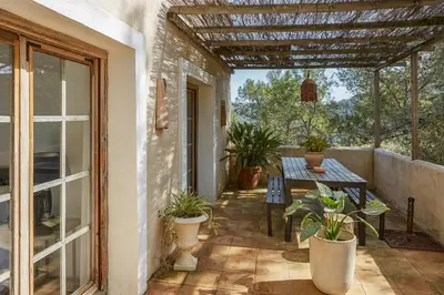an outdoor patio with a table and potted plants at Villa Hermosa at Masia Nur Sitges, Adults only in Canyelles