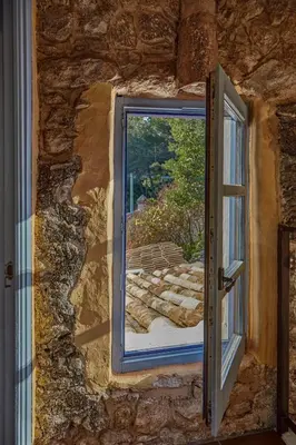 a window in a stone wall with a view at Casa Azul at Masia Nur Sitges, Adults only in Canyelles