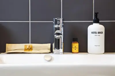 a bathroom sink with a faucet and a bottle of soap at Hotel Brick Barcelona in Barcelona
