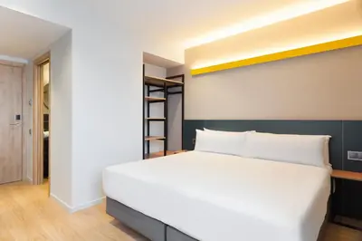 a bedroom with a large white bed and a ladder at Hotel Brick Barcelona in Barcelona