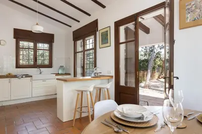 a kitchen with a table and chairs and an open door at Luxury Villa El Turo in Castellví de Rosanés